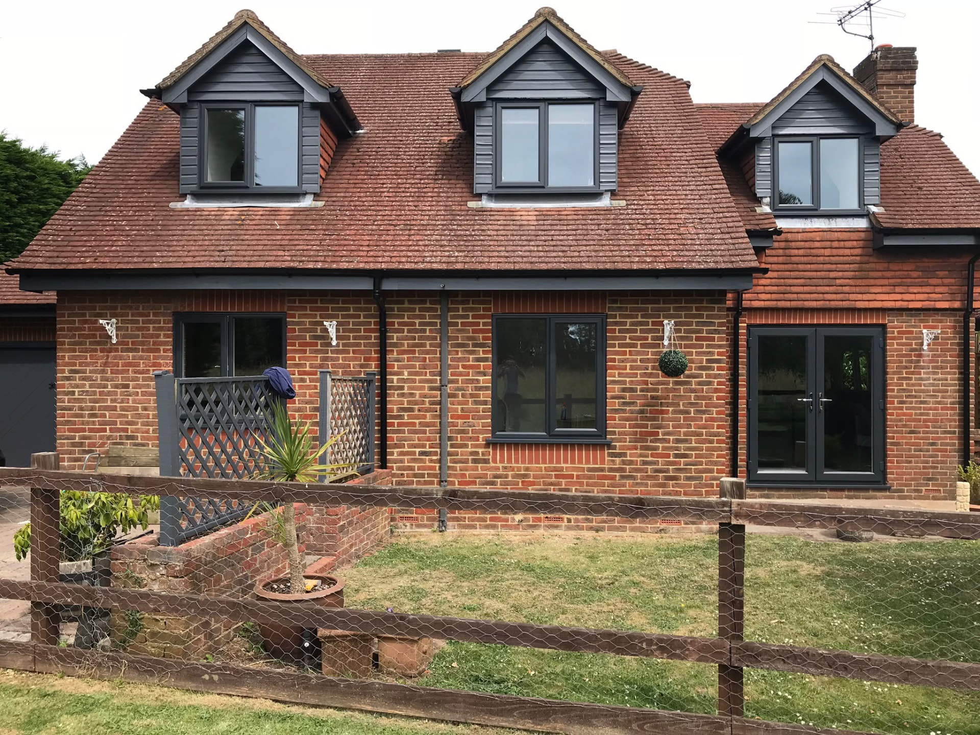 Grey double glazed windows and dormer windows across a whole-house installation