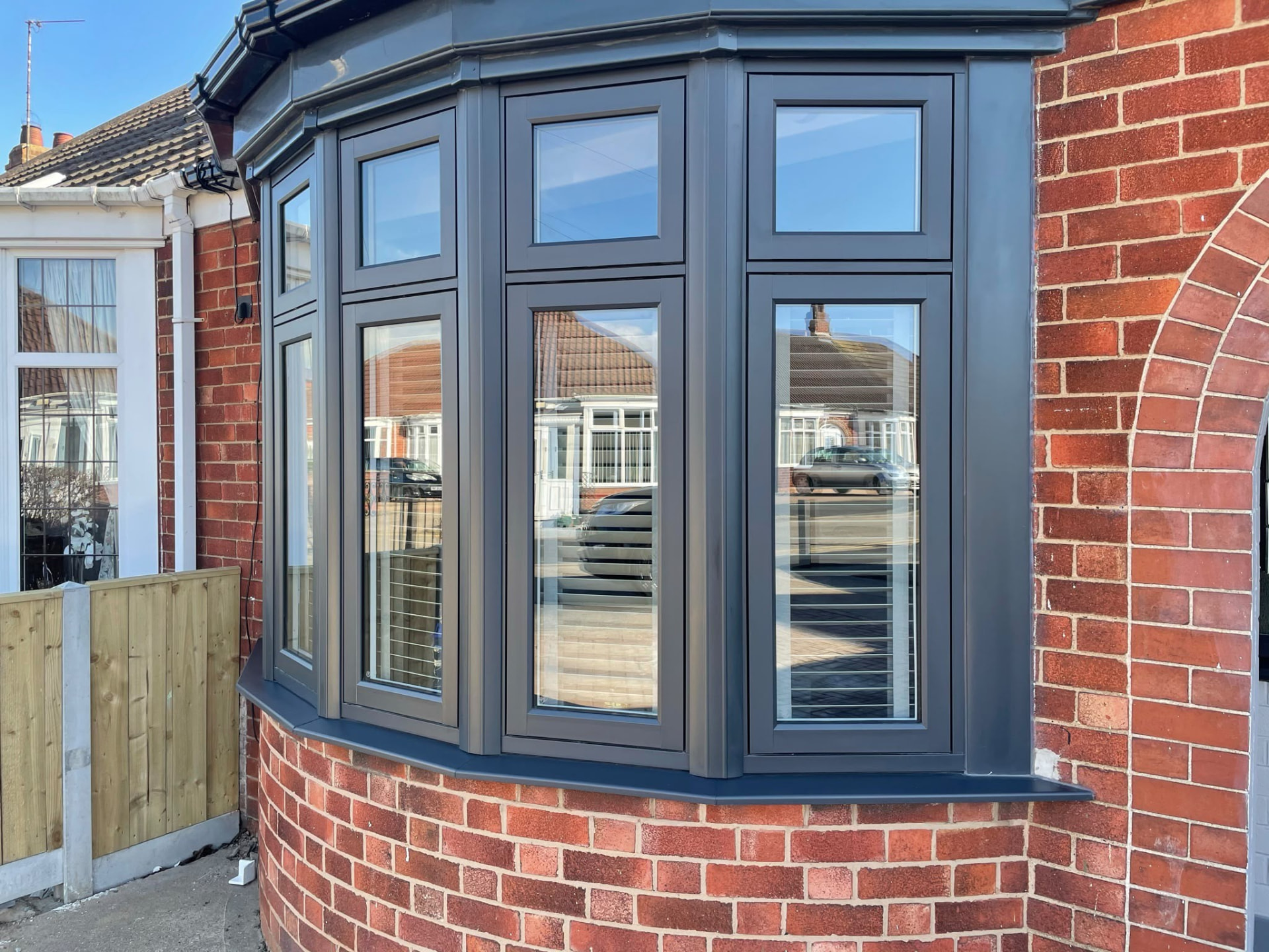 Anthracite grey UPVC bay window installed on a red brick house by Draycote Windows