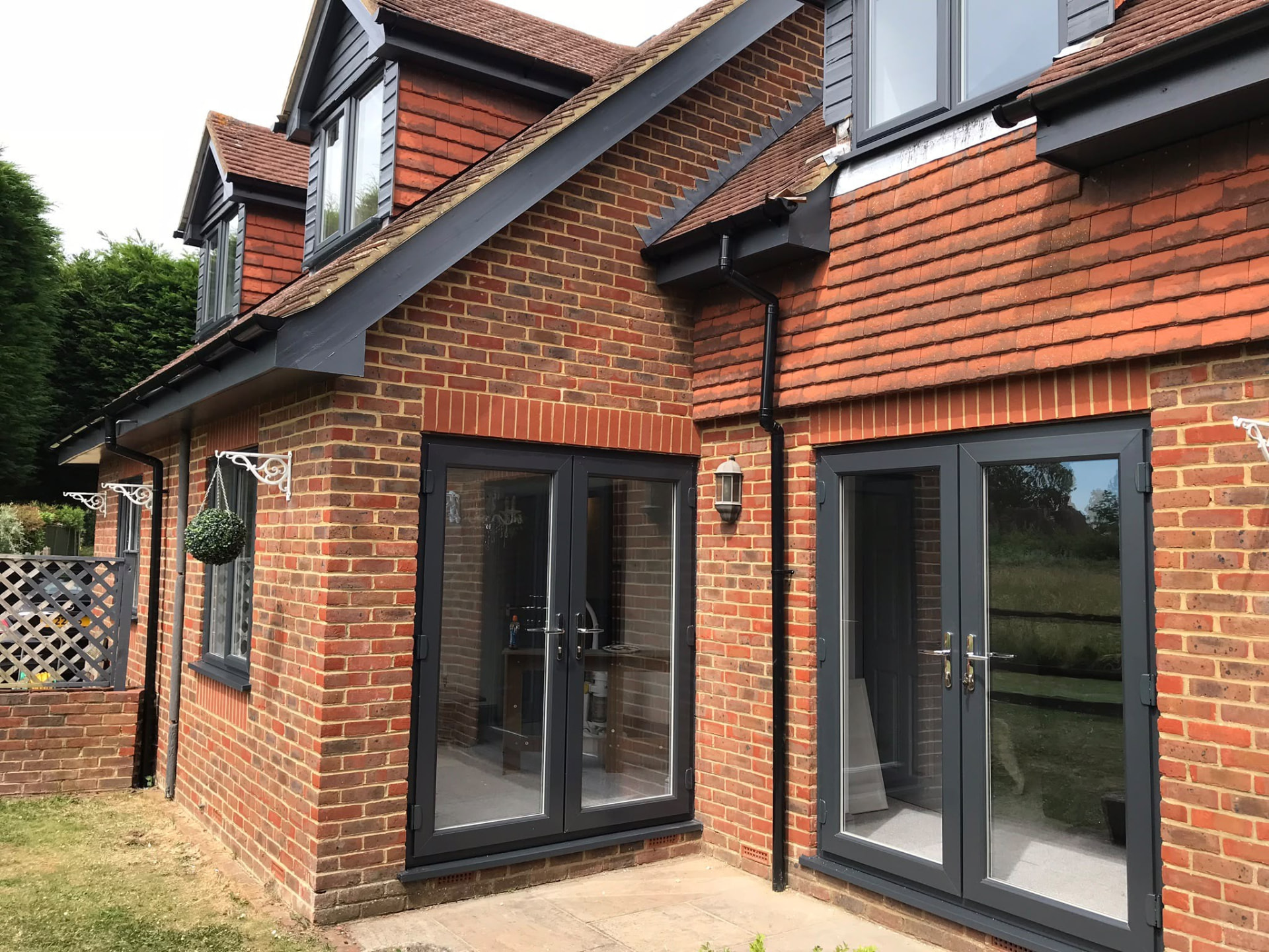 Anthracite grey French doors installed on a brick garden room by Draycote Windows