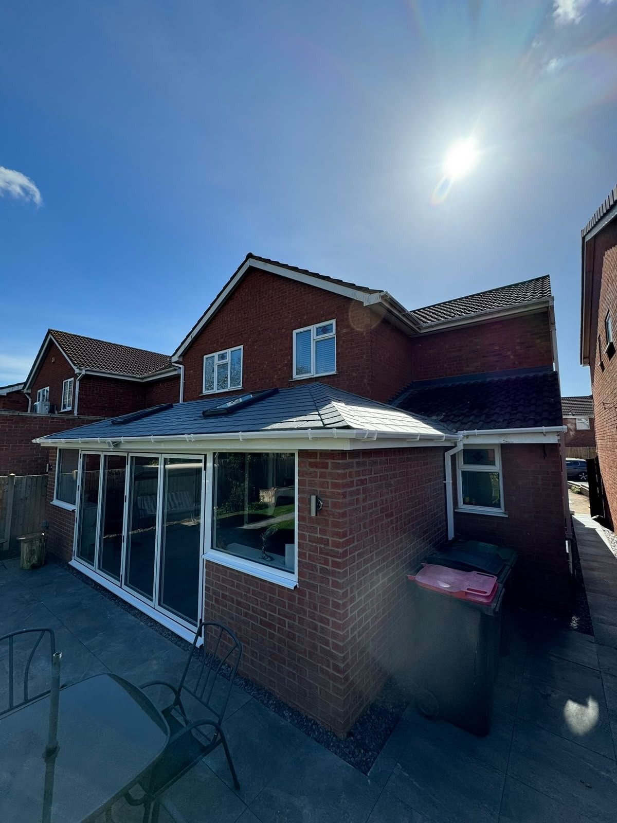 Rear conservatory with an insulated tiled warm roof and white frames