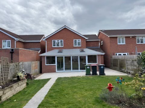 Rear garden view of a conservatory fitted with an insulated tiled warm roof