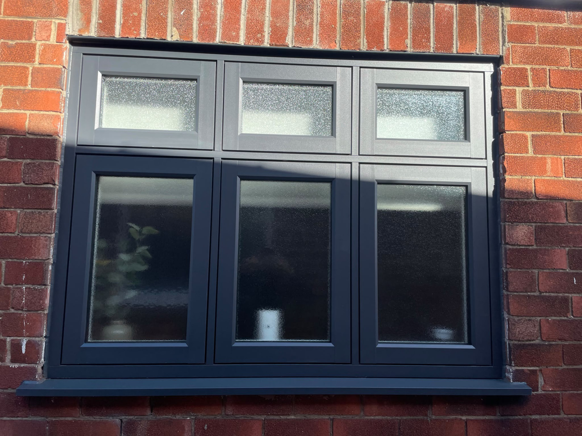 Anthracite grey UPVC casement window fitted to a red brick home by Draycote Windows