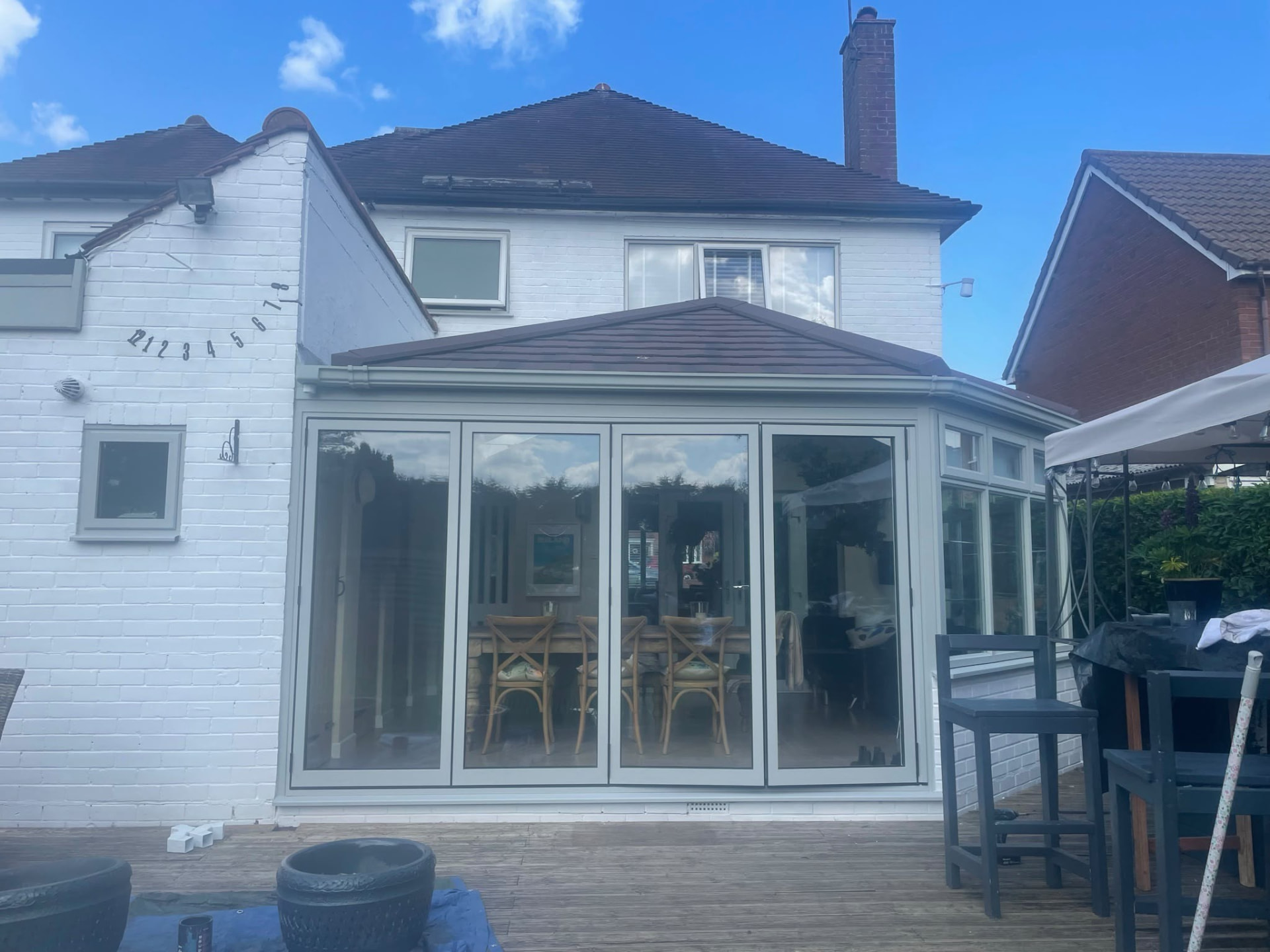 Conservatory converted with an insulated tiled warm roof on a white rendered house