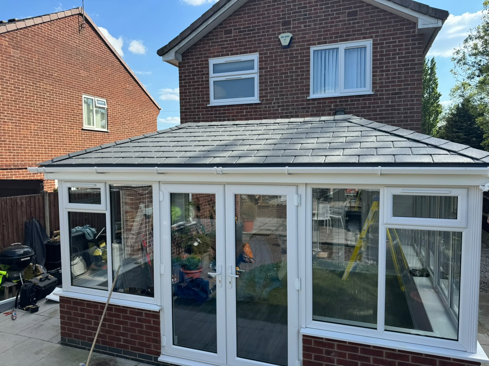 Conservatory roof replacement with slate-effect tiles on a detached house