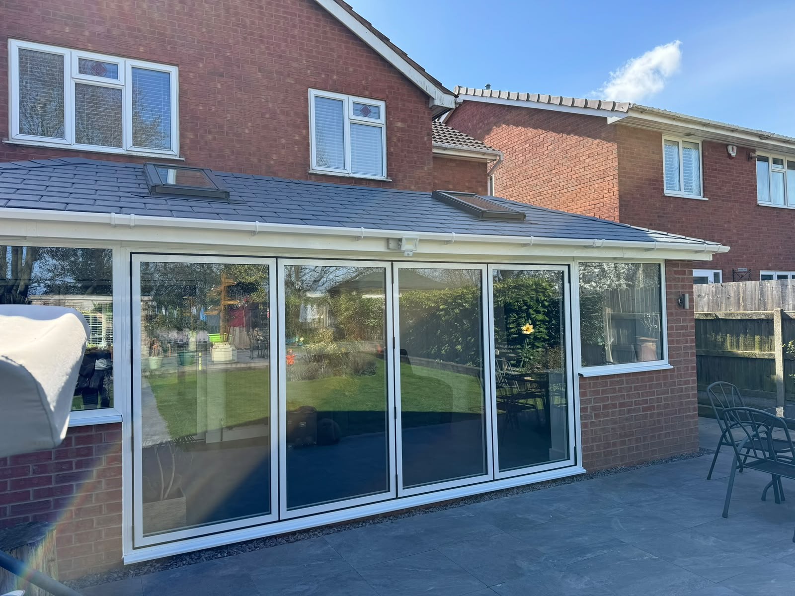Tiled warm roof fitted over a wide rear conservatory with sliding doors
